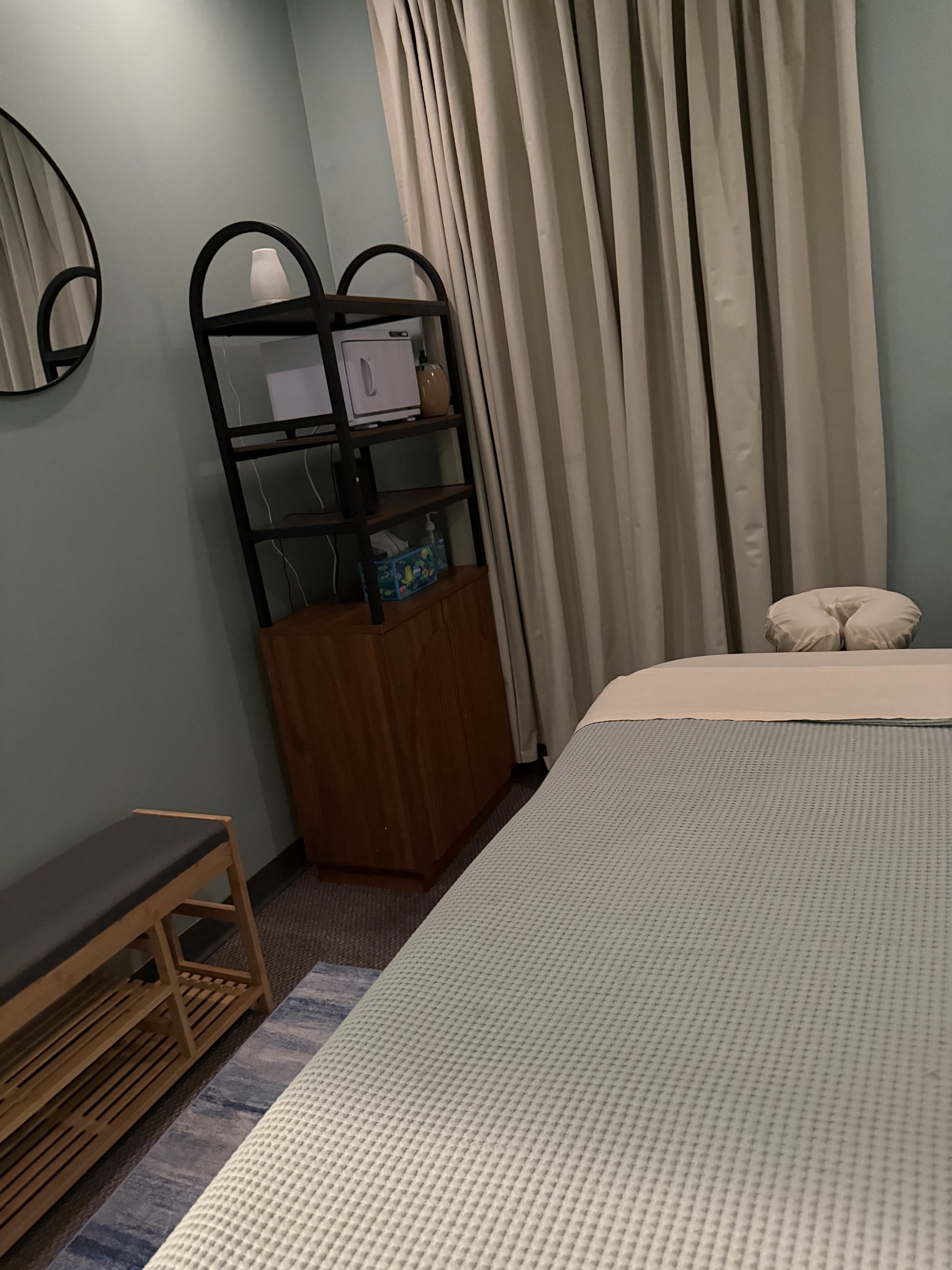 Private massage room with a prepared table and soft curtains