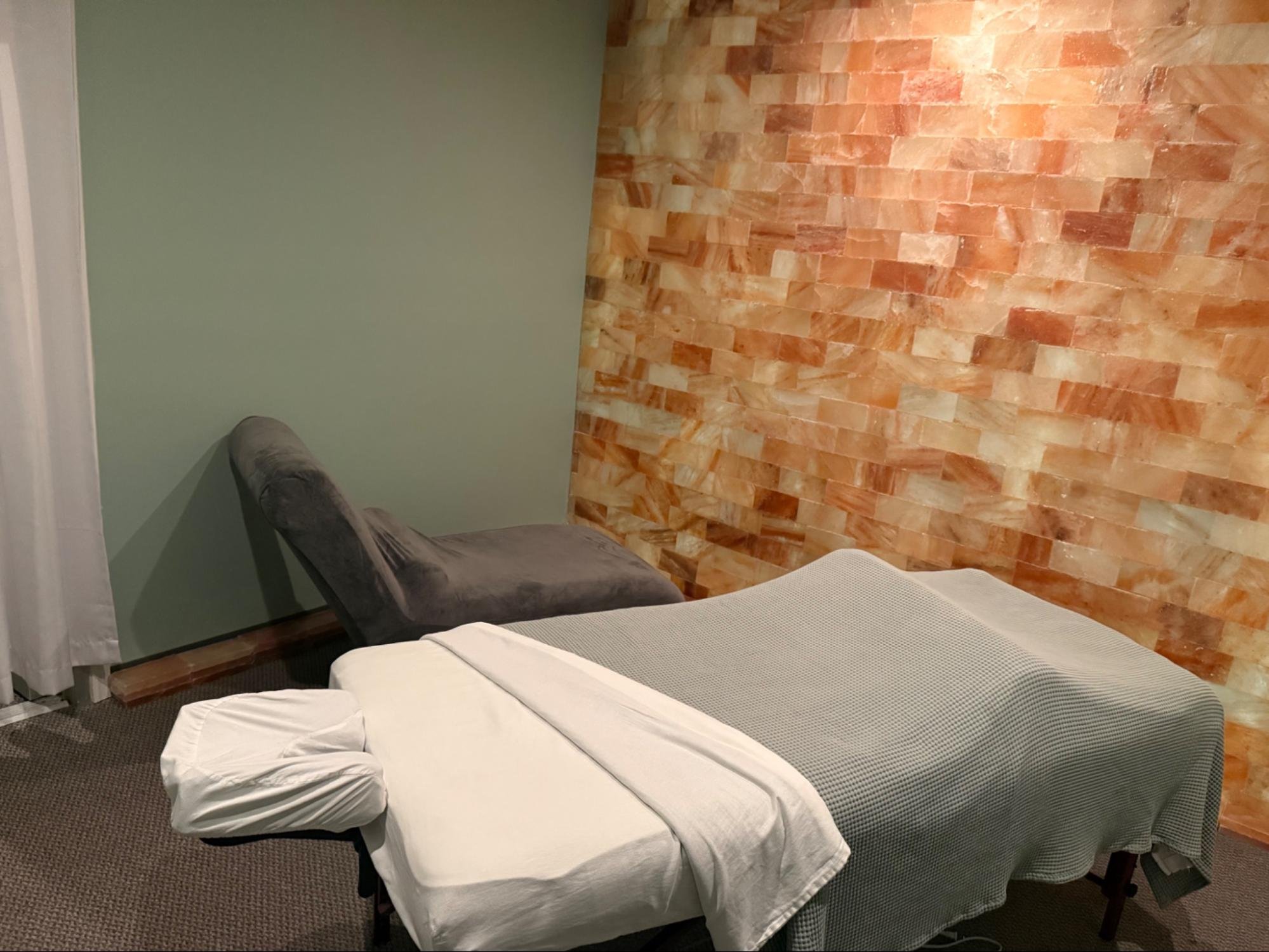 Salt room with a massage table and privacy curtain